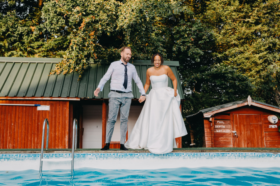 Newlyweds before jumping into the pool – an authentic moment captured in a spontaneous wedding photo.