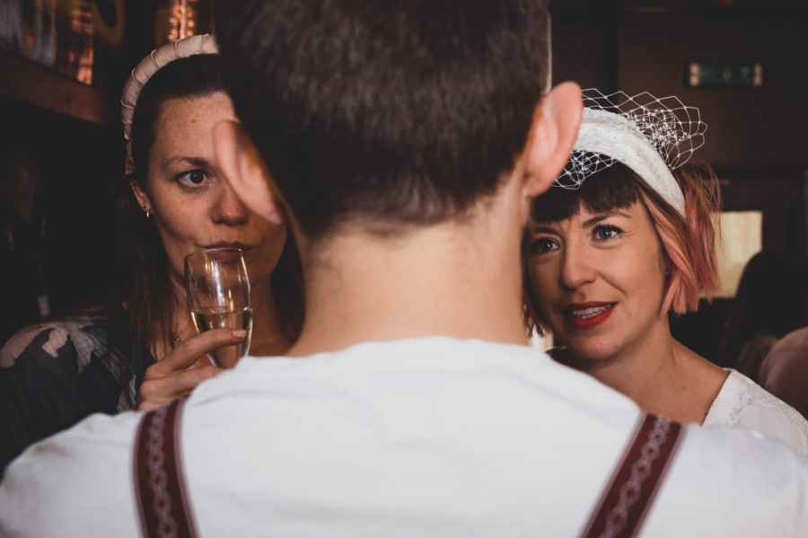Two women in conversation at a wedding, captured through candid photography for a natural, unposed moment.